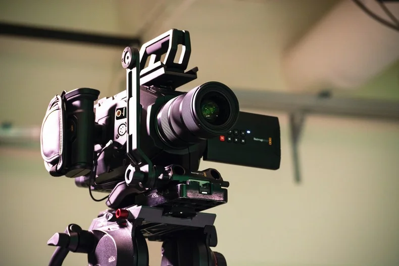 A video camera on a tripod.
